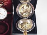 a silver pocket watch with a world map inside of it