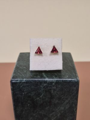 a pair of red garnets sit on top of a black marble block