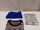 three sweaters, one blue and one grey, are sitting on a table