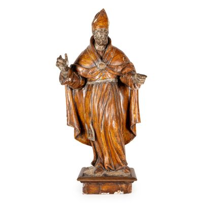 une vieille statue en bois représentant un homme coiffé d'un chapeau et vêtu d'une robe