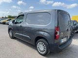 the back of a grey van parked in a parking lot