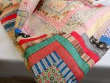 a patchwork quilt on a bed with a pillow on it