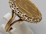 a close up of a gold ring with a coin on it