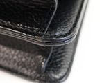 a close up of a black leather wallet on a white surface
