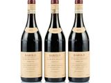 trois bouteilles de vin rouge posées l'une à côté de l'autre sur une surface blanche