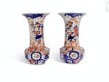 two vases sitting side by side on a white surface