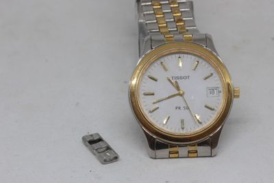 une montre-bracelet en argent et en or avec un cadran blanc