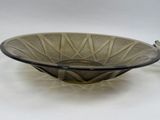 a glass bowl with a metal handle on a table
