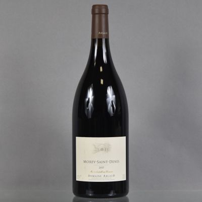 une bouteille de vin posée sur une table à côté d'un verre