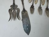 many spoons and spoon knives hanging on a wall