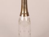an old fashioned glass bottle with a gold lid and a metal stopper