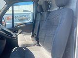 the interior of a white van with a grey seat and a black steering wheel