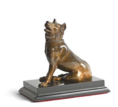 bronze statue of a dog sitting on a base on a white background
