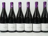 six bottles of red wine are lined up in a row