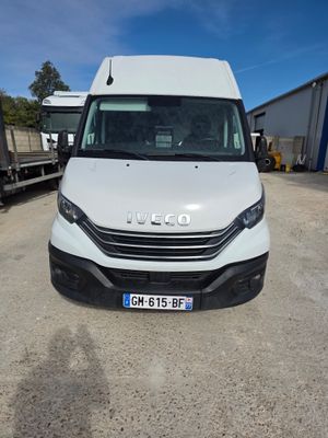 une camionnette blanche garée dans un parking à côté d'autres véhicules