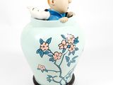 a small figurine of a man sitting in a vase