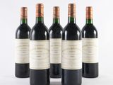 four bottles of wine are lined up on a white surface
