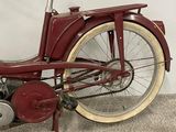 a red bicycle that is parked against a wall