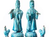 three figurines of a man with a bird on his shoulder