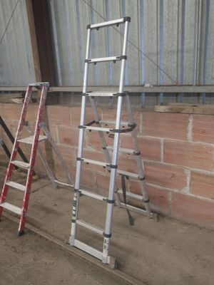 deux échelles appuyées contre un mur de briques