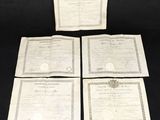 four certificates of various sizes and shapes on a black background