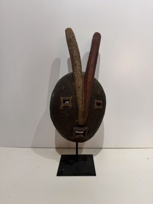 an image of a sculpture of a face with two horns sticking out of it ' s mouth