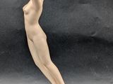 figurine of a nude woman on a gold ball on a black background