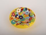 une assiette jaune ornée d'un motif floral coloré