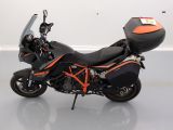 an image of a black and orange motorcycle parked in a room