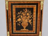 a small cabinet with a vase of flowers on it