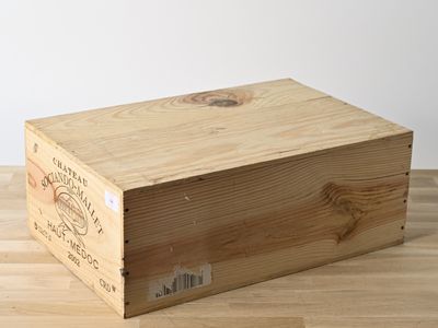 une caisse en bois sur laquelle est apposée une étiquette, posée sur un plancher en bois