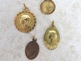 trois médailles d'or représentant Jésus et Marie sur un socle en marbre