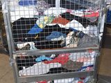 a metal cart filled with lots of clothes in a warehouse