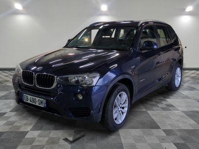 une photo d'un SUV BMW bleu garé dans un garage