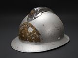 a silver helmet with a gold emblem on it