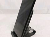 a close up of a cell phone on a stand on a white surface