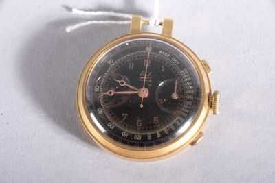 a gold watch with a black face on a white surface