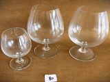 three empty wine glasses sitting next to each other on a table
