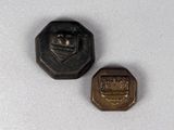 deux petits boutons métalliques posés sur une surface blanche