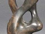 statue of a woman ' s face on a base with a gray background