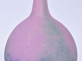 un vase violet et bleu posé sur une surface blanche