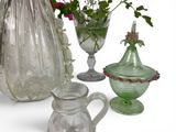 several glass vases and vases with flowers in them on a white surface