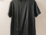 a black t - shirt hanging on a wall next to a hanger