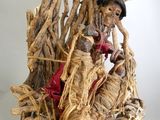 une statue représentant une femme assise au sommet d'un tas de bois