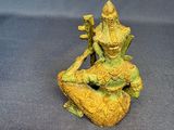 an image of a statue of a person sitting on a rock