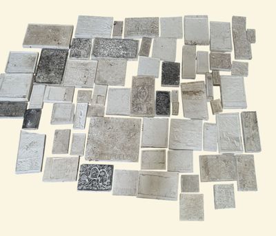 a picture of a pile of silver tiles on a white background