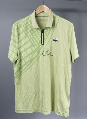 a green polo shirt with a picture of a crocodile on it