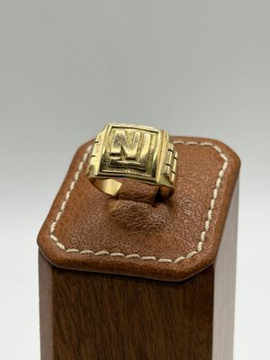 an image of a gold ring on a brown leather box