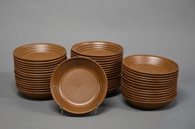 six assiettes marron empilées les unes sur les autres sur une surface grise
