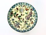 a plate with a design of butterflies and flowers on it